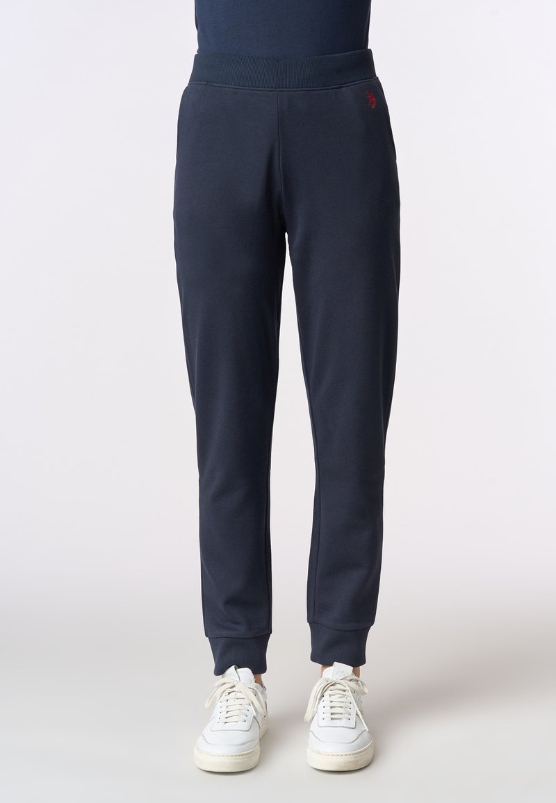 Pantaloni jogger blu navy realizzati in morbido tessuto, con vita elasticizzata, polsini a coste e un piccolo dettaglio del logo rosso.