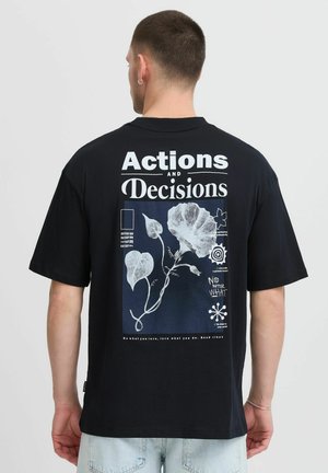 Camiseta de algodón negra con un estampado gráfico en la parte posterior, que presenta texto blanco e ilustraciones florales en colores contrastantes.