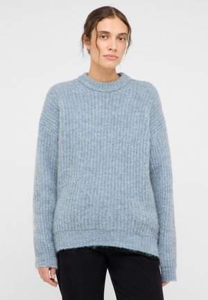 Hellblauer Strickpullover mit gerippter Textur, rundem Ausschnitt und lockerer Passform. Der Saum ist hinten etwas länger.