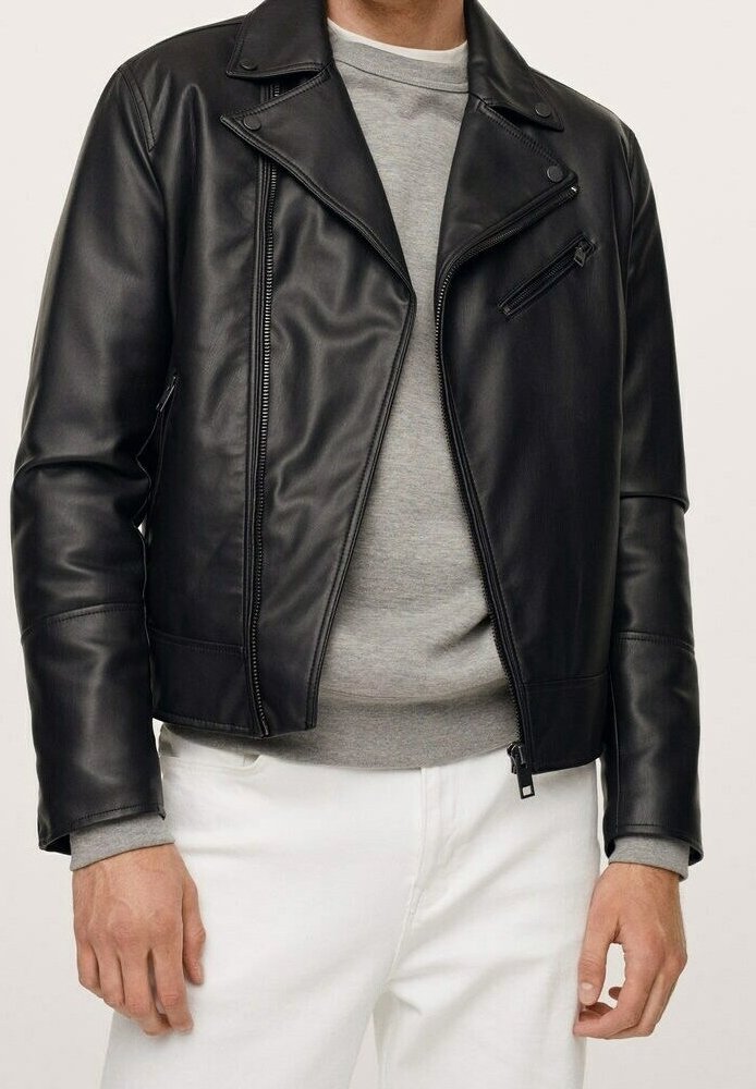 Giacca da motociclista in pelle nera con design sagomato, zip asimmetrica e colletto con bottone a pressione. Indossata sopra un maglione grigio e pantaloni bianchi.