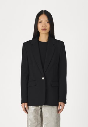 Svart skreddersydd blazer med notched lapels og enkel knappelukking. Har to frontlommer og strukturerte skuldre. Glatt stoffstruktur.