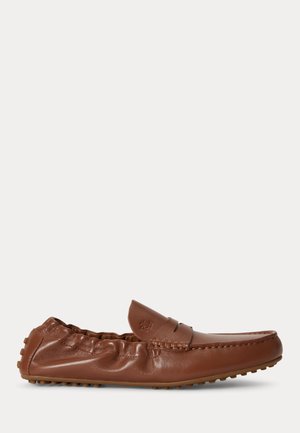 Mocassin en cuir marron avec talon élastiqué, chaussure à enfiler, détails cousus et semelle en caoutchouc à picots pour une bonne adhérence.