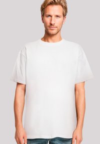White t-shirt made of cotton, featuring a crew neck and short sleeves, designed in a relaxed fit with a smooth texture.