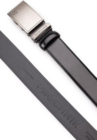 Czarny skórzany pasek z prostokątną metalową klamrą. Klamra ma matowe wykończenie i jest wygrawerowana napisem "PRÓCHNIK", a na pasku znajduje się napis "NICKEL FREE".