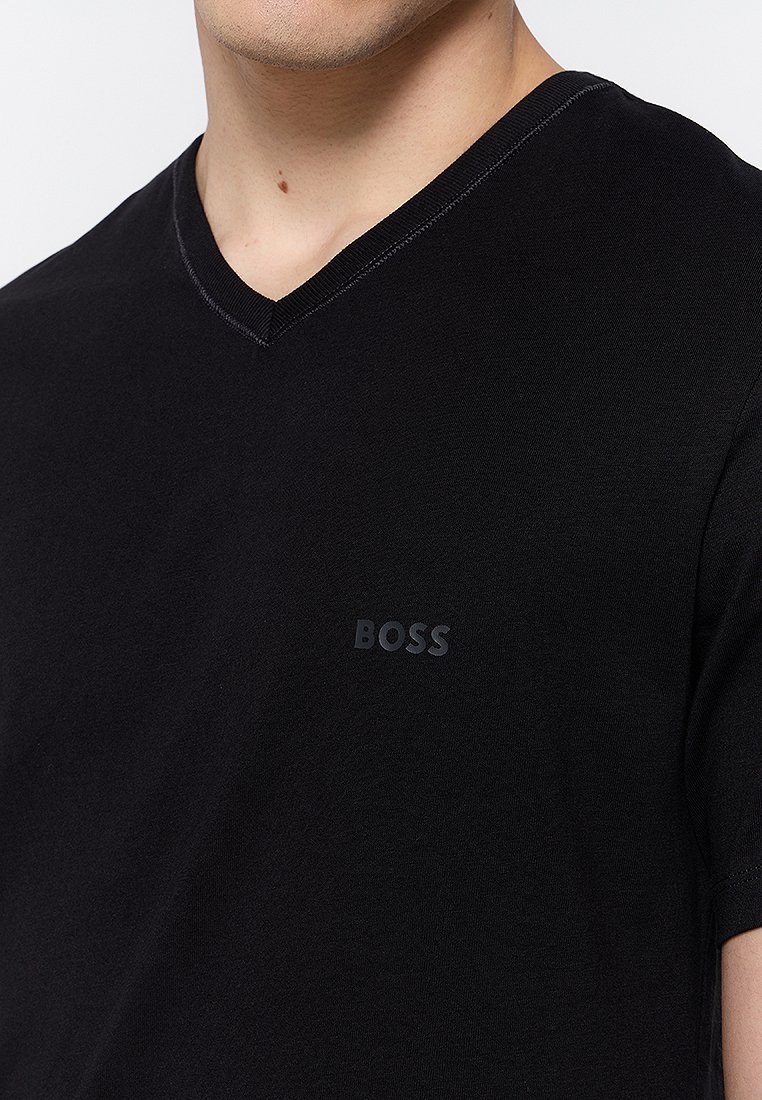 Camiseta de manga corta negra hecha de algodón suave. Cuenta con un sutil escote en V y un logo "BOSS" negro mate en el lado izquierdo del pecho.
