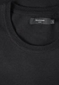 Musta neulepusero, jossa on Matinique Europe -merkki ja kokoa L oleva lappu kauluksessa.