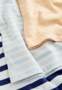 Tissu en coton doux avec des rayures horizontales pastel bleu, crème, marine et rose clair, montrant des bords pliés qui se chevauchent.