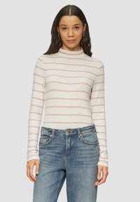Weißes Langarm-Turtleneck-Oberteil mit hellrosa horizontalen Streifen, kombiniert mit blauen Denim-Jeans. Weicher Stoff mit taillierter Passform.
