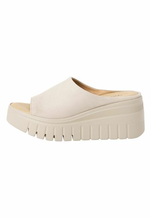 Sandale à talon compensé beige avec tige en daim lisse, design à bout ouvert, et semelle épaisse texturée présentant des rainures horizontales distinctes.