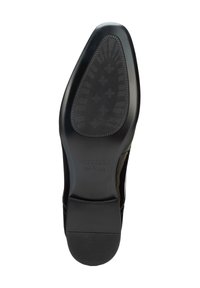 Schwarze Ledersohle eines Schuhs mit strukturiertem Gummi für besseren Halt, leicht erhöhter Absatz und eingeprägter Markenname.