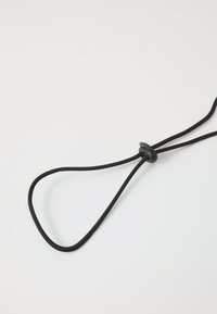 Svart justerbar stropp laget av flettet materiale, med en sentral plastknapp for størrelsesjustering og en løkke-design i begge ender.