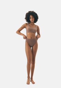 Brązowy dwuczęściowy strój kąpielowy składający się z dopasowanej bluzki na szerokich ramiączkach i spodenek z wysokim stanem, wykonany z gładkiego, elastycznego materiału.
