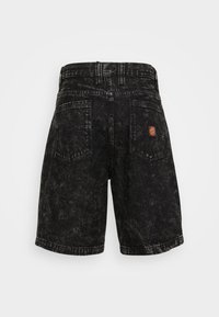 Calções de ganga pretos com um efeito de desbotado, design de cinco bolsos e um pequeno emblema circular no bolso traseiro. Apresenta um corte reto.