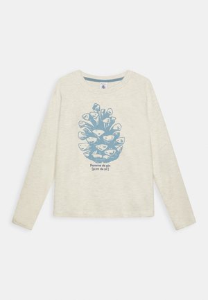 Roomwit shirt met lange mouwen, met een blauwe dennenappelillustratie en Franse tekst "Pomme de pin [pɔm də pɛ̃]" gecentreerd op de voorkant.