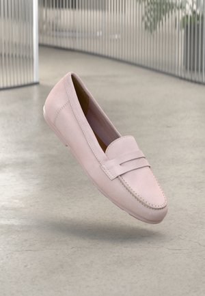 Lyserød mokkasin med en suede-lignende tekstur, der har en syet detalje og en enkelt rem over vristen. Flad såldesign.