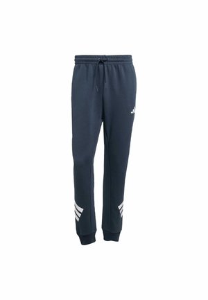 Pantalons de survêtement bleu marine avec taille élastique et cordon de serrage. Présente des rayures blanches en diagonale sur le bas des jambes. Texture douce et poignets fuselés.