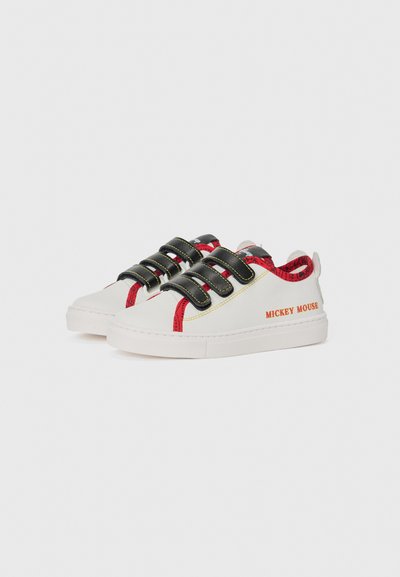 Weiße Sneakers mit schwarzen Riemenverschluss, roten Akzenten und gelben Nähten; verfügt über den Schriftzug "MICKEY MOUSE" an der Seite.