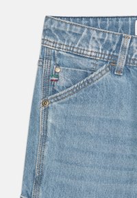 Jeans de mezclilla azul claro con un corte clásico. Cuentan con cierre de botón, bolsillos frontales y un detalle de costura colorida en el bolsillo.