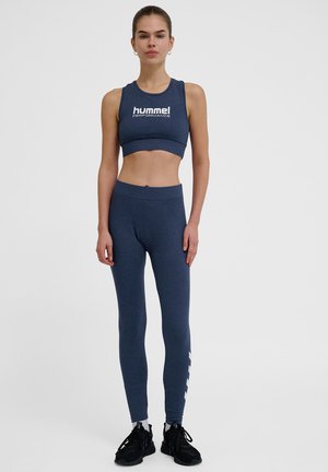 Granatowy zestaw stanik sportowy i legginsy z elastycznego materiału, z logo na staniku i białym wzorem po boku legginsów.