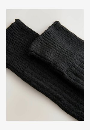 Mustad mustrilõksud, millel on sooniline tekstuur, esitlevad pehmet ja karvane villast materjali. Omavad voltimisosa, et tagada lisamugavus.