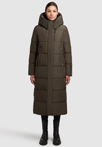 Garšs pūkains mētelis olīvzaļā krāsā, ar kapuci, horizontālu quilted rakstu, ar rāvējslēdzēja priekšējiem kabatām un taisnu griezumu.