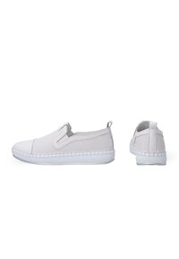 Weiche Slip-On-Schuhe aus weißem Netzmaterial mit einer festen weißen Zehenkappe und Gummisohle. Sie besitzen ein strukturiertes Design und eine praktische Schlaufe hinten.