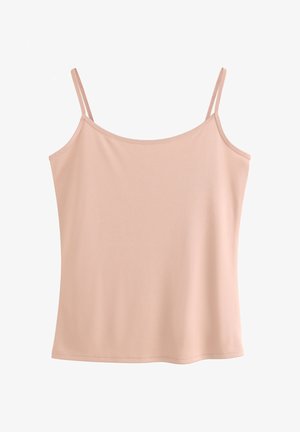 Mujer con cabello largo y castaño, vestida con una camiseta beige y ropa interior a juego con encaje, de espaldas contra un fondo claro y liso.