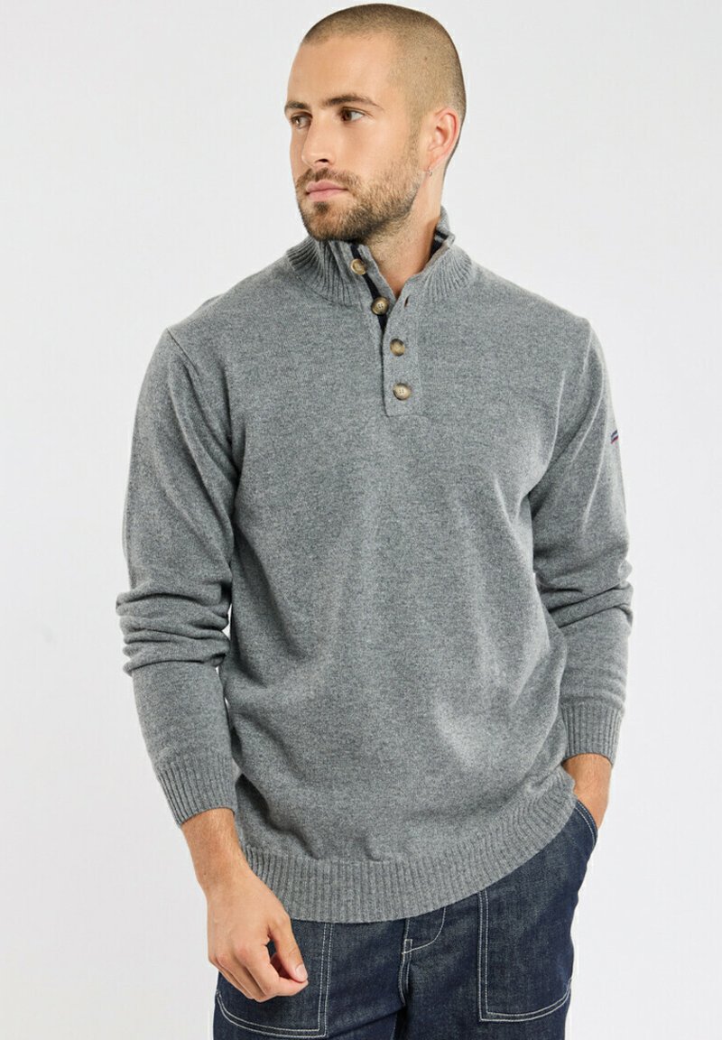 Pull-over en tricot gris avec un col haut, une patte de boutonnage à trois boutons et des bords ribés. Présente une finition texturée.