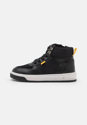 Zwarte hoge sneaker met witte zool, gele trekker en veterhaak, paneel met mesh en leer, zijaanzicht tegen een witte achtergrond.