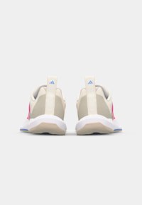 Beige joggesko med rosa detaljer, med en teksturert overdel, trekkfliker og en hvit såle med blå detaljer.