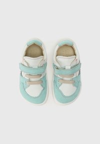 Λευκά και τιρκουάζ αθλητικά παπούτσια με γλώσσα από δίχτυ, λουράκι βέλκρο και αντίθετη ραφή. Μαλακά υλικά από σουέντ και λείο δέρμα.