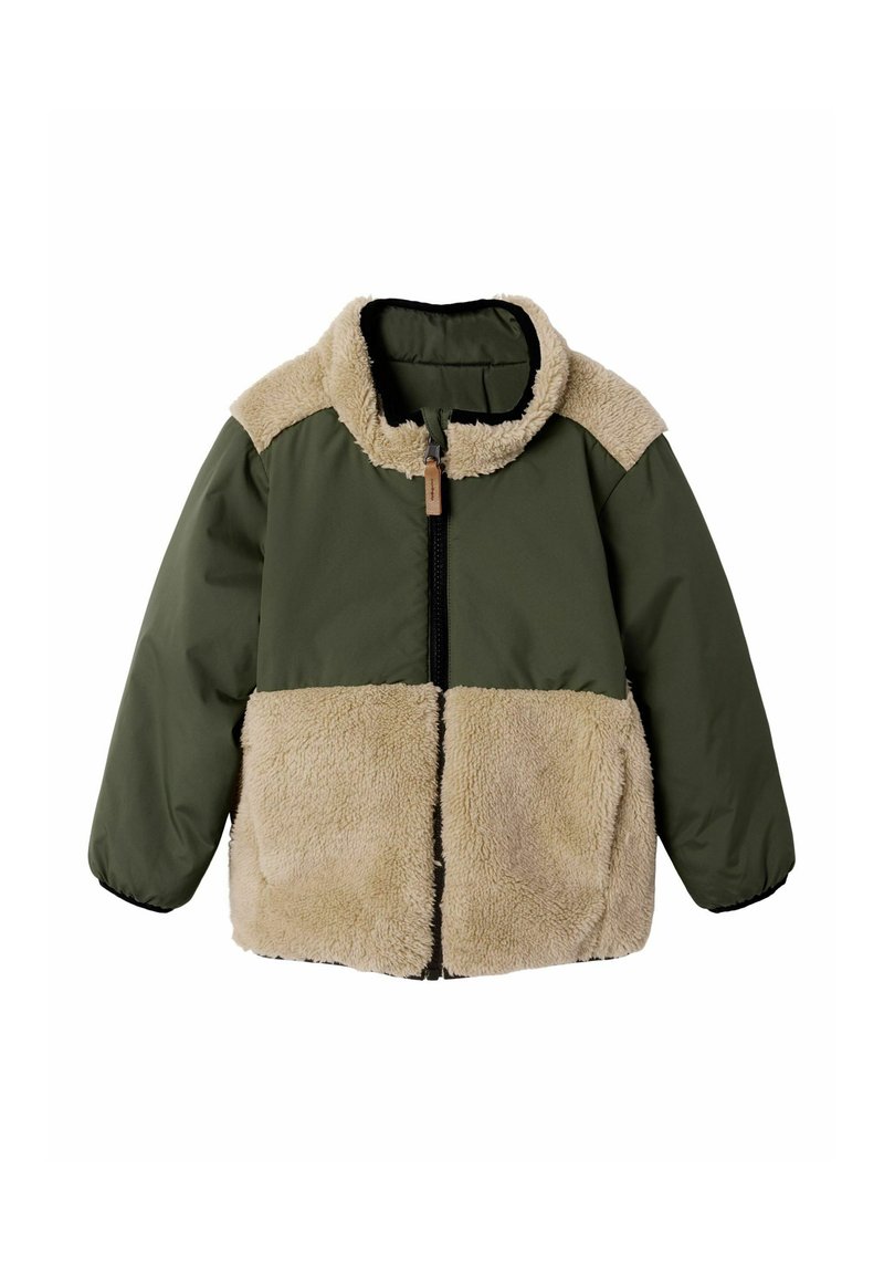 Grøn jakke med beige imiteret fåreskind på krave, bryst og nederste del, med en lynlås foran og lange ærmer.