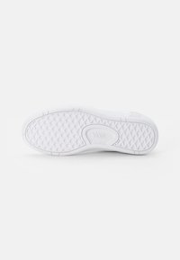 White Vans sneaker sole with a textured, patterned grip design, featuring a smooth finish and a visible logo at the side.