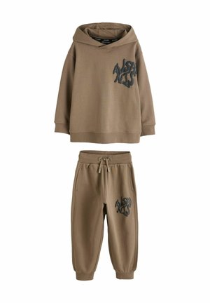 Brauner Hoodie mit einem großen schwarzen Logo auf der Brust, kombiniert mit passenden Jogginghosen. Beide Kleidungsstücke haben eine weiche, strukturierte Oberfläche.