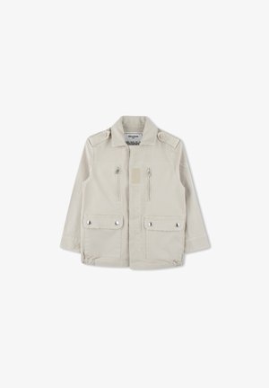 Beige kinderjas van katoen, met een ritssluiting aan de voorkant, twee borstzakken met kleppen en knoopdetails op de schouders.