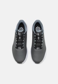 Pantofi sport negri și gri cu partea superioară din plasă, vârf rotund, șireturi plate și talpă albă. Prezintă accente gri pe limbă și pe laturi.