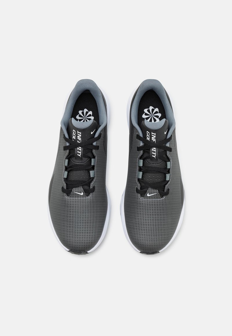 Schwarze und graue Sportschuhe mit einem Obermaterial aus Mesh, runder Zehenpartie, flachen Schnürsenkeln und weißer Sohle. Mit grauen Akzenten an der Zunge und den Seiten.