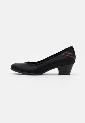 Escarpin noir à talon bas en matériau synthétique texturé, avec un bout arrondi et un discret accent rouge sur l'étiquette latérale.