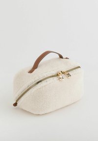 Kremowa puszysta kosmetyczka z brązowym uchwytem z ekologicznej skóry, złotym zamkiem błyskawicznym i zawieszkami na zamek w kształcie pandy. Okrągły kształt i miękka tekstura.