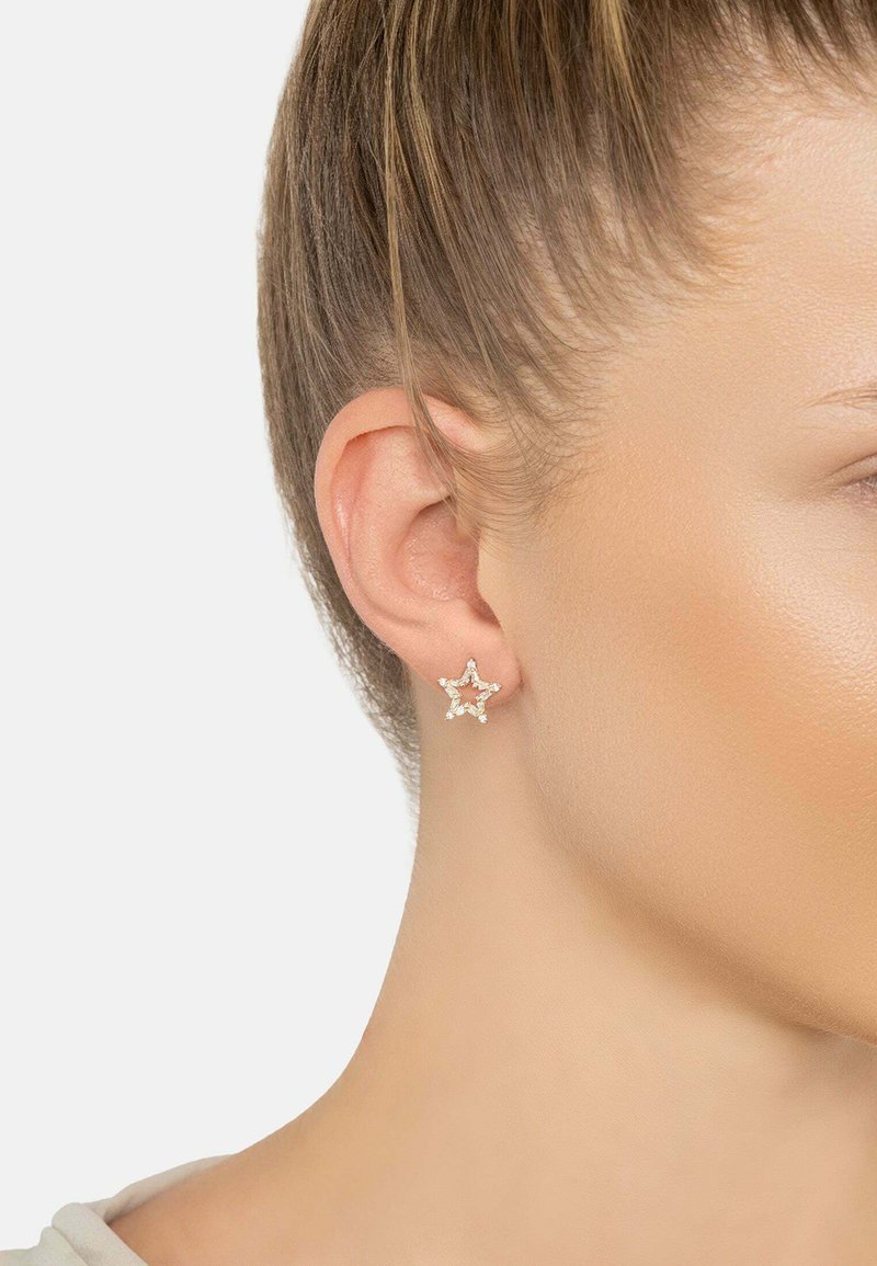 Gold-tone star-shaped earrings embellished with clear gemstones, featuring a smooth metallic finish and fine detailing around the edges.