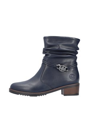 Botte de cheville en cuir bleu marine avec un haut décontracté, un accent métallique circulaire et une semelle texturée. Elle présente un talon bas empilé et un détail de logo subtil.