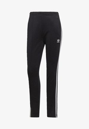 Juodos sportinės kelnės iš minkštos medžiagos, su baltais šoninėmis juostomis, elastinga juosmeniu ir priekinių kišenių. "Adidas" logotipas kairėje šlaunies pusėje.