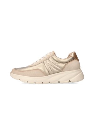Zapatilla deportiva beige con una mezcla de materiales lisos y texturizados. Presenta costuras sutiles, punta redondeada y una suela gruesa.