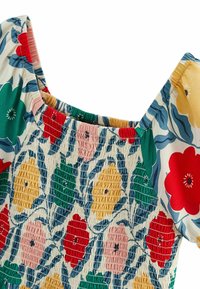 Haut smocké à motifs floraux avec manches courtes, décolleté carré et fleurs colorées en rouge, vert, jaune et rose sur fond crème.