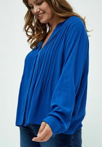 Blusa blu con maniche lunghe, caratterizzata da pieghe verticali, scollatura a V e polsini con bottone. Realizzata in un tessuto morbido e strutturato.