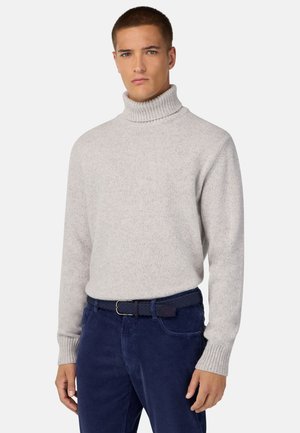 Lichtgrijze coltrui met geribbelde manchetten, gemaakt van zachte stof. Gecombineerd met donkerblauwe fluwelen broek en een gevlochten riem.