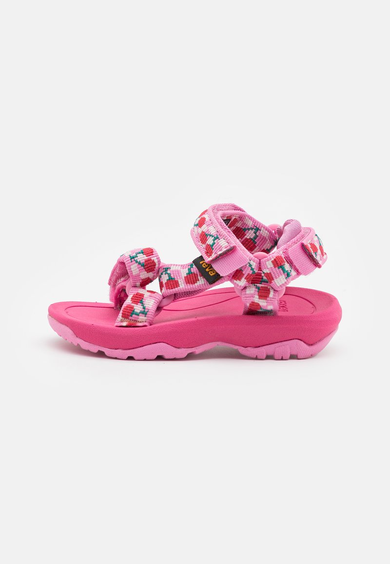 Pink sandals with patterned straps featuring red, blue, and white details. Textured rubber sole with an adjustable design for a snug fit.