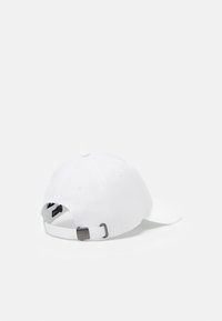 White cotton baseball cap with a curved brim, featuring a silver buckle strap at the back and ventilation holes on the crown.