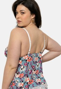 Débardeur floral bleu avec des fleurs roses et blanches, doté de fines bretelles blanches et d'une dentelle au bas. Tissu texturé avec une coupe décontractée.