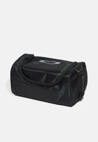 Zwarte synthetische tas met een rechthoekige vorm, voorzien van een ritssluiting aan de bovenkant, een ingekrast logo en zijhandvatten voor gemakkelijk dragen.